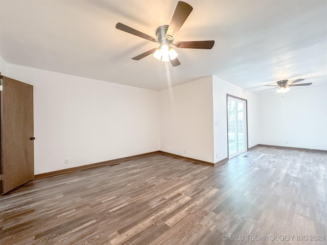 empty room with hardwood / wood-style floors and ceiling fan