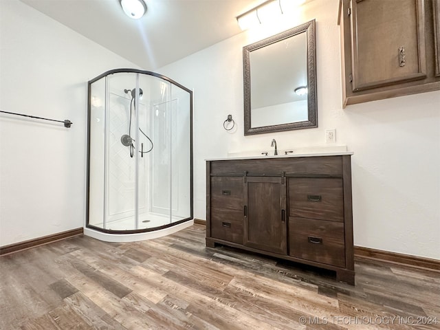 bathroom featuring hardwood / wood-style floors, vanity, and a shower with shower door