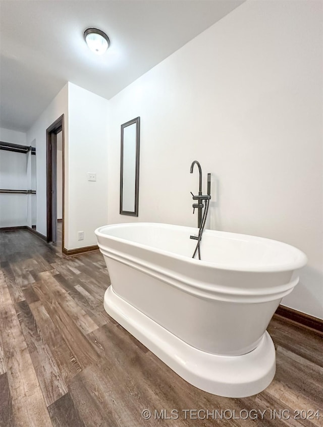 bathroom with a bathing tub and hardwood / wood-style floors