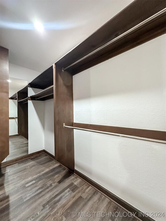 spacious closet with dark hardwood / wood-style floors