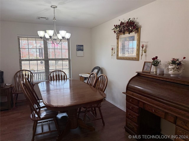 dining area featuring dark hardwood / wood-style floors and an inviting chandelier