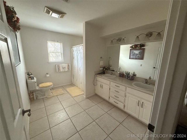 bathroom featuring tile patterned flooring, vanity, and toilet