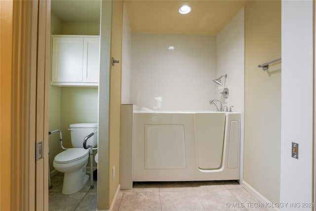 bathroom featuring tile patterned flooring, toilet, and a tub