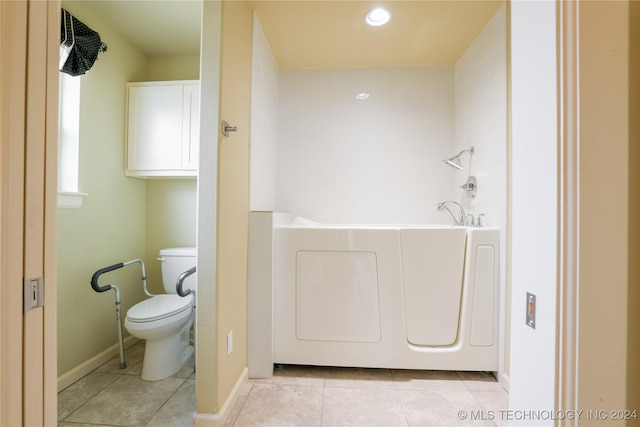 bathroom with tile patterned flooring, toilet, and a tub