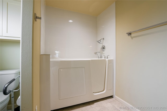 bathroom with tile patterned floors, a bathtub, and toilet