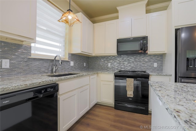 kitchen featuring pendant lighting, sink, tasteful backsplash, and black appliances