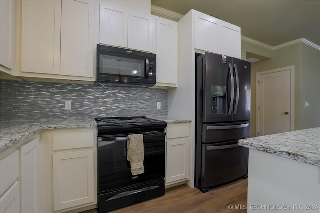 kitchen featuring white cabinetry, light stone countertops, light hardwood / wood-style flooring, backsplash, and black appliances