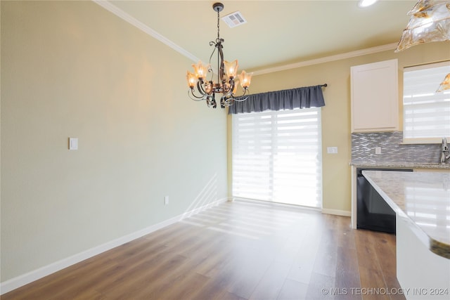 kitchen with decorative backsplash, hardwood / wood-style flooring, an inviting chandelier, black dishwasher, and hanging light fixtures