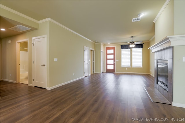 unfurnished living room with a tiled fireplace, ceiling fan, dark hardwood / wood-style flooring, and crown molding