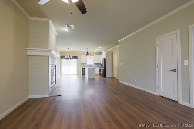 unfurnished living room featuring crown molding, a fireplace, dark wood-type flooring, and ceiling fan with notable chandelier