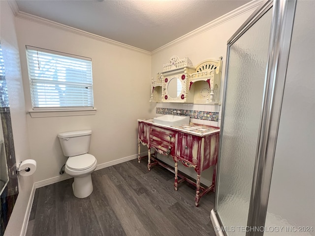 bathroom with hardwood / wood-style flooring, an enclosed shower, ornamental molding, and sink