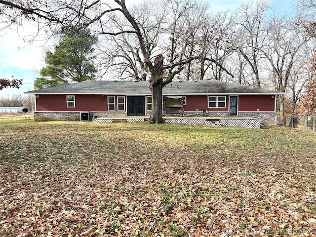 back of house featuring a lawn and a wooden deck