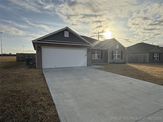 ranch-style house with central AC unit and a garage