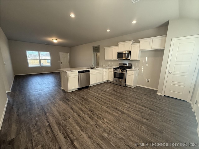 kitchen featuring kitchen peninsula, appliances with stainless steel finishes, dark hardwood / wood-style floors, and white cabinetry