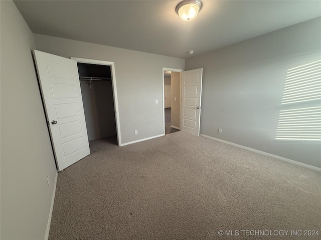 unfurnished bedroom featuring carpet floors and a closet