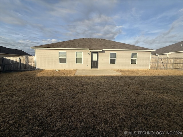 rear view of house with a yard and a patio