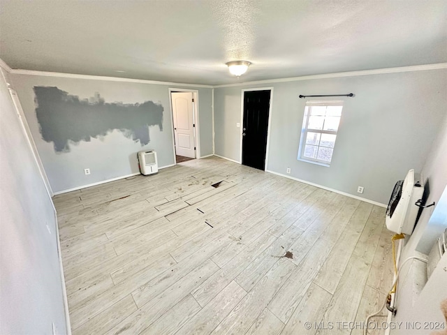 interior space with light hardwood / wood-style floors, a textured ceiling, and ornamental molding