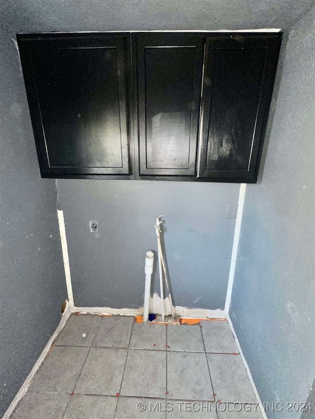 laundry room featuring cabinets and tile patterned floors