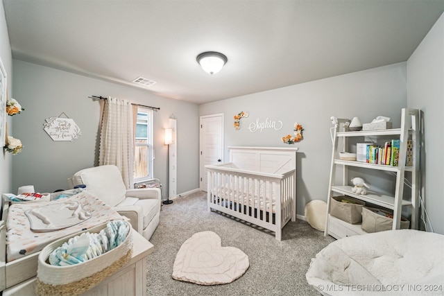 bedroom with light colored carpet and a nursery area