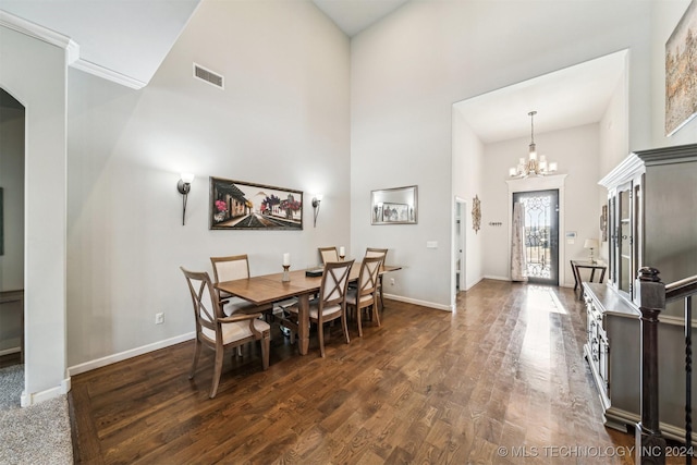 dining space with a notable chandelier, dark wood-type flooring, and a high ceiling