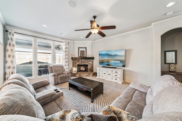 carpeted living room with ceiling fan, ornamental molding, and a brick fireplace