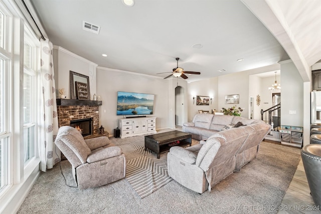 living room featuring a fireplace, ceiling fan with notable chandelier, light hardwood / wood-style floors, and ornamental molding