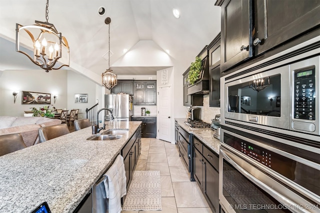 kitchen featuring light stone countertops, sink, pendant lighting, and appliances with stainless steel finishes