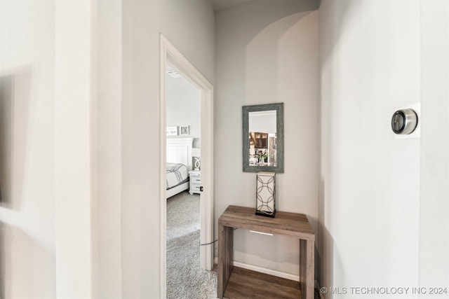 hallway featuring dark colored carpet