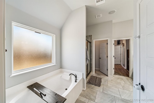 bathroom featuring separate shower and tub and lofted ceiling