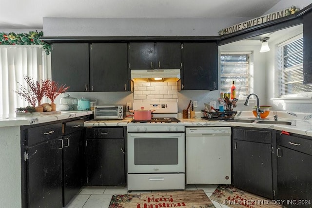 kitchen with light tile patterned floors, white appliances, tasteful backsplash, and sink