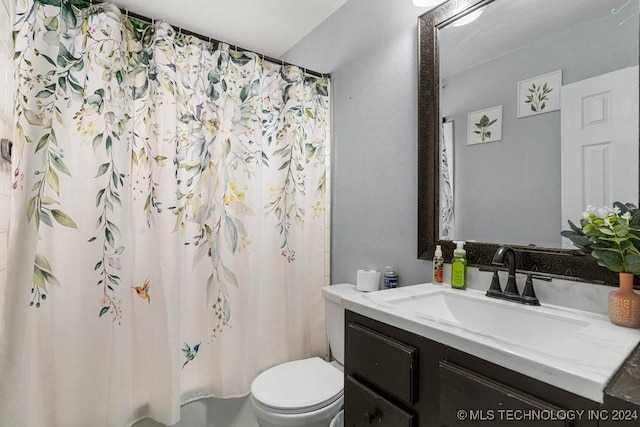 bathroom featuring vanity, curtained shower, and toilet