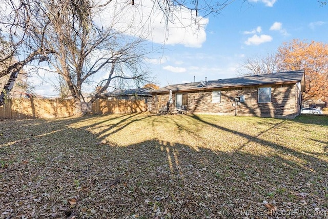 rear view of house featuring a yard