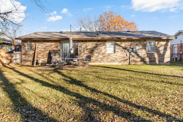 rear view of property with a patio and a lawn