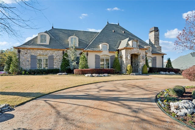 french country style house with a front yard