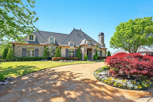 10616 S Forest Ave, Jenks, OK 74037 - french country home featuring stucco siding, a chimney, stone siding, and a front lawn