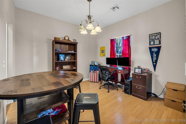 home office with a notable chandelier and light hardwood / wood-style floors