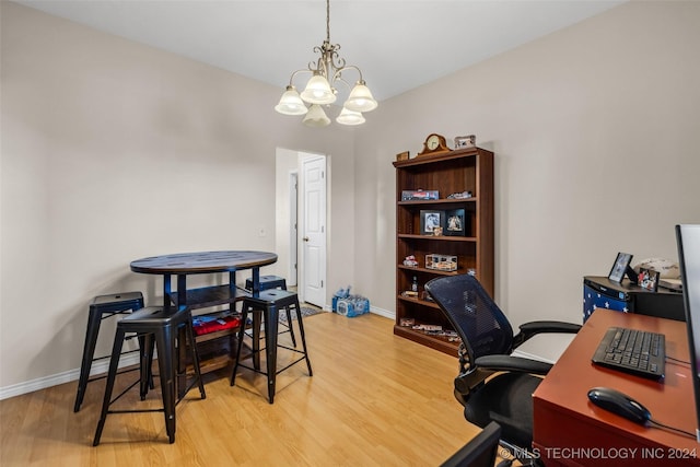 home office featuring light hardwood / wood-style floors and an inviting chandelier