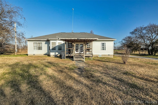 rear view of property featuring french doors, a deck, and a lawn