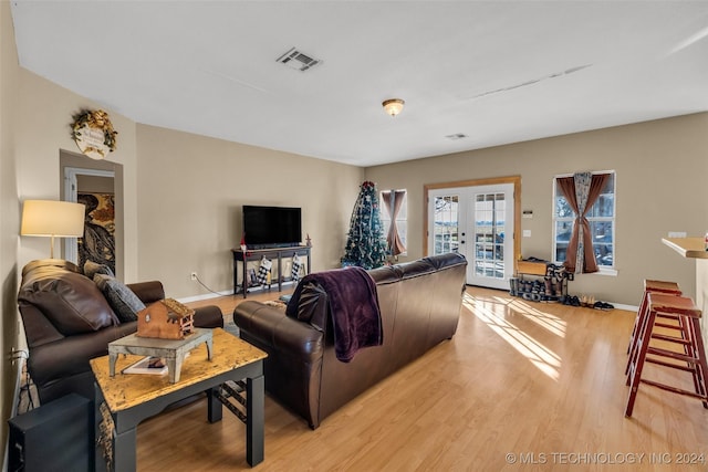 living room featuring bowling, light hardwood / wood-style flooring, and french doors