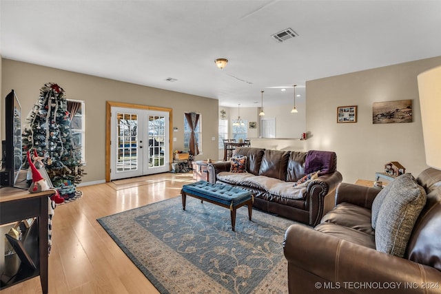 living room featuring french doors and light hardwood / wood-style flooring