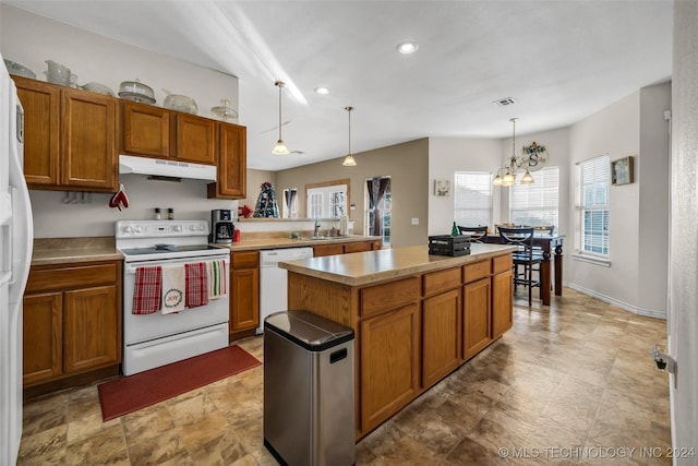 kitchen with white appliances, sink, pendant lighting, an inviting chandelier, and a kitchen island