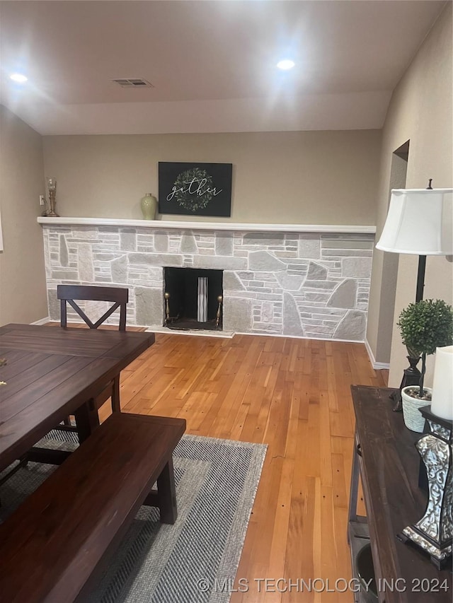 living room featuring hardwood / wood-style floors and a stone fireplace