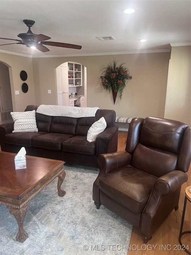 living room with ceiling fan and ornamental molding