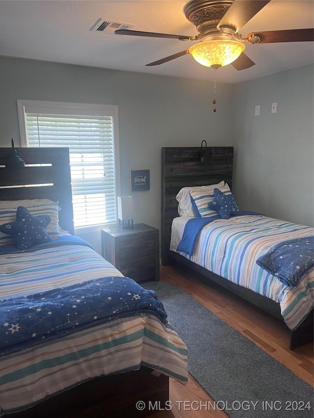 bedroom with dark hardwood / wood-style floors and ceiling fan