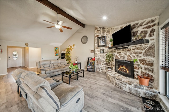 living room with lofted ceiling with beams, light hardwood / wood-style floors, plenty of natural light, and a fireplace