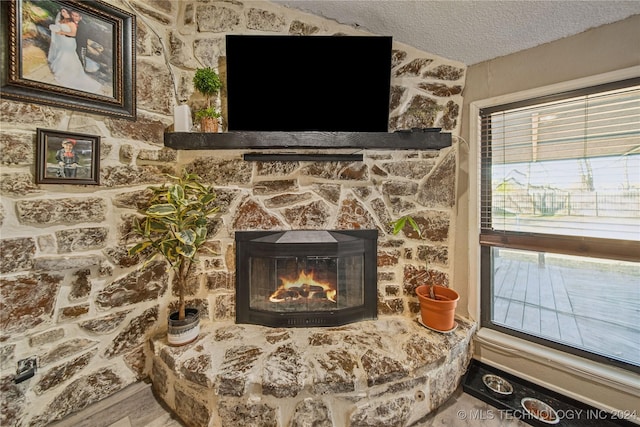 interior details featuring a fireplace, hardwood / wood-style floors, and a textured ceiling