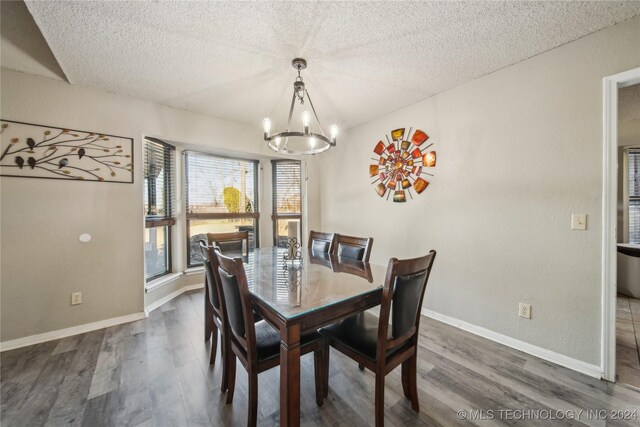 dining area featuring a textured ceiling, dark hardwood / wood-style floors, and an inviting chandelier