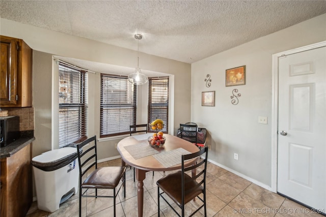 tiled dining space with a textured ceiling