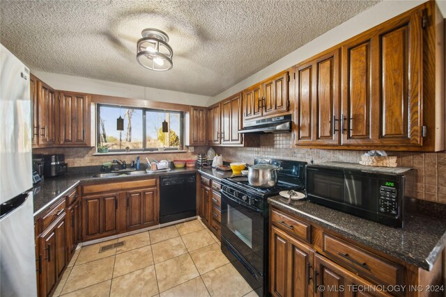 kitchen with tasteful backsplash, a textured ceiling, sink, black appliances, and light tile patterned floors