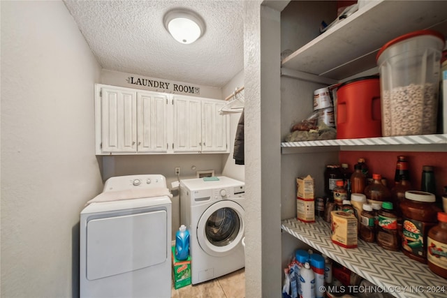 washroom with cabinets, separate washer and dryer, a textured ceiling, and light tile patterned floors